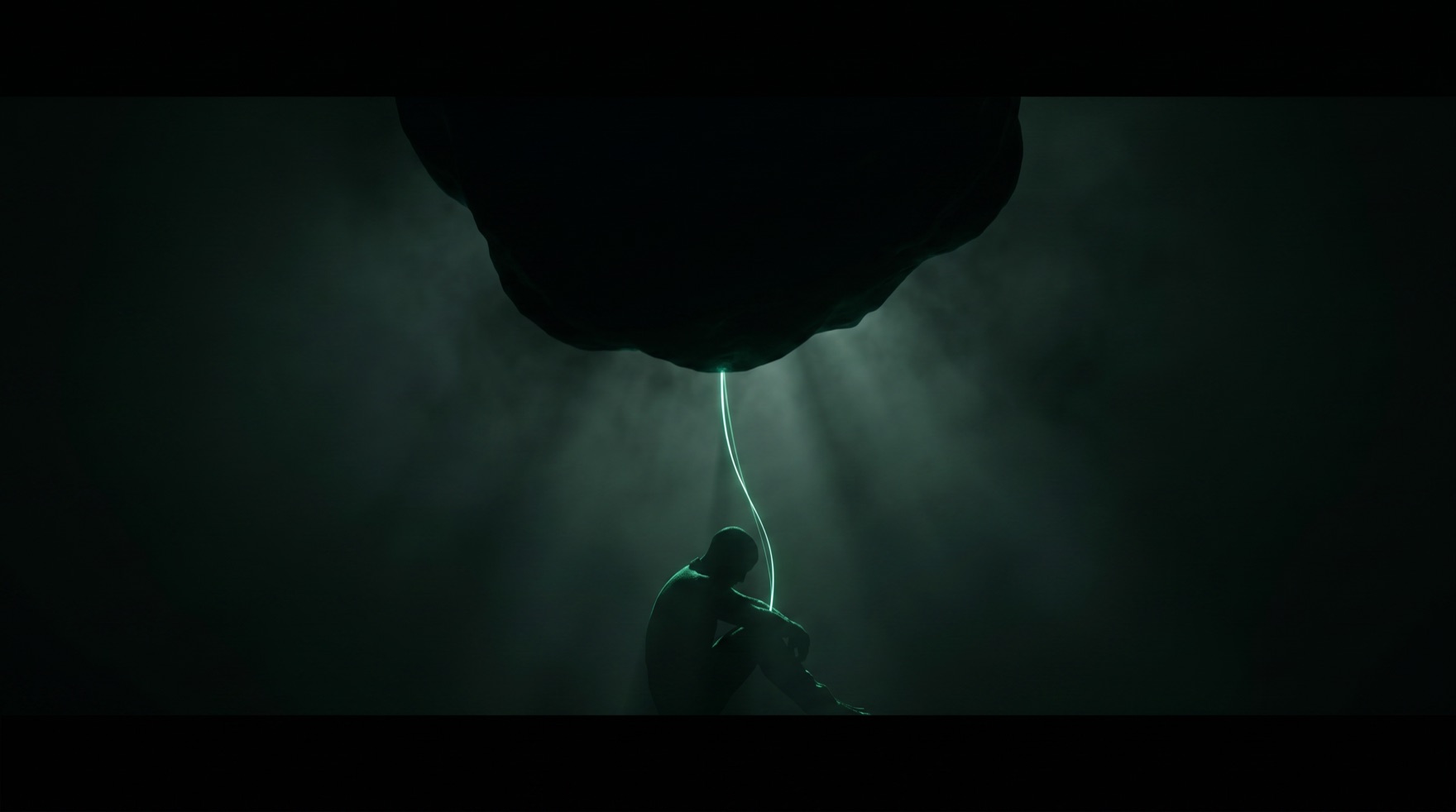 A lone figure sits in near-darkness at the foot of the frame, dwarfed by a vast looming mass above, a single thread of emerald light connecting them, the weight of a decision carried alone.